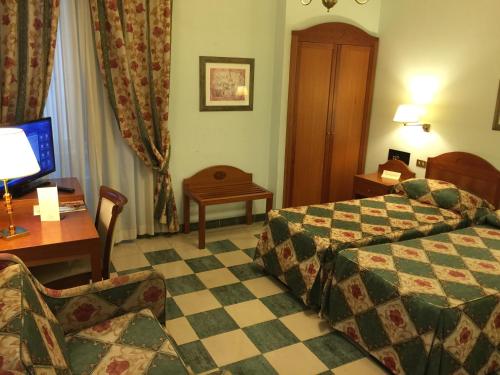 a hotel room with a bed and a table and a desk at Hotel Aberdeen in Rome