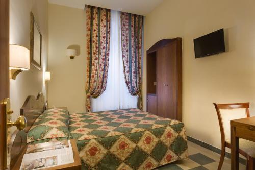 a bedroom with a bed and a desk at Hotel Aberdeen in Rome