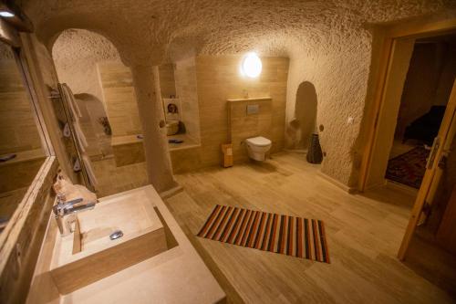 a large bathroom with a sink and a toilet at Maze Of Cappadocia Hotel in Uchisar