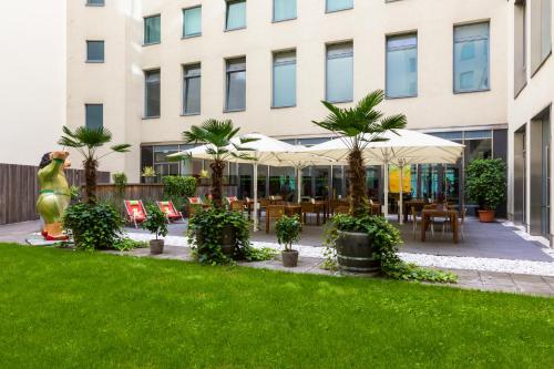 a courtyard with palm trees and a building at Lindner Hotel Berlin Ku'damm, part of JdV by Hyatt in Berlin