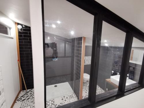 een badkamer met een glazen raam en een bad bij Gite Mimosa in Saint-Florent-des-Bois