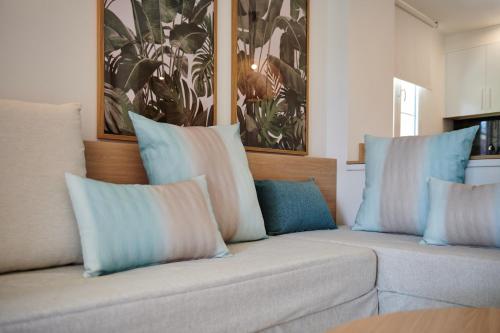 a couch with blue and white pillows on it at Grupotel Club Turquesa Mar in Son Xoriguer