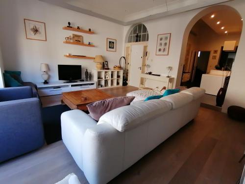 uma sala de estar com um sofá branco e uma mesa em Brugmann Loft Apartment em Bruxelas