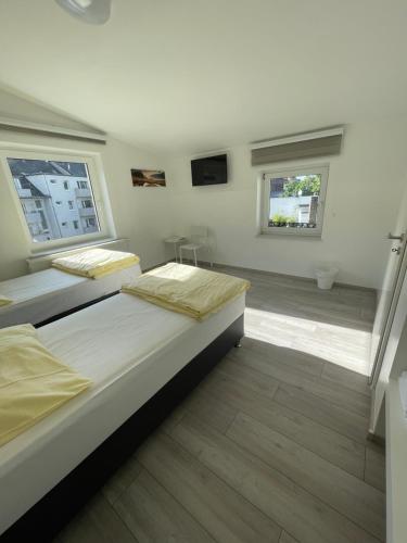 two beds in a room with two windows at Apartment Dusseldorf-City in Düsseldorf