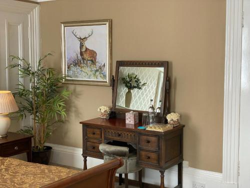 a desk with a mirror and a picture on the wall at Ernespie House Hotel in Castle Douglas