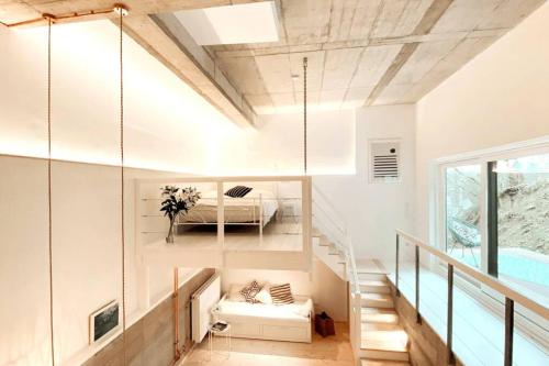 a white room with a bed and a staircase at Pool-Loft: Wandern, Erholen & Sauna Siebengebirge in Erpel