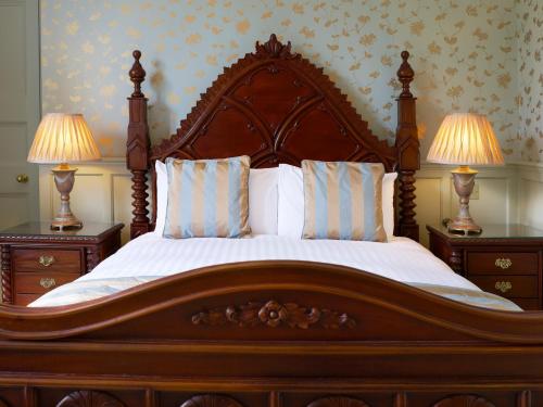 a large wooden bed with two night stands and two lamps at The Wrea Head Hall Country House Hotel & Restaurant in Scarborough