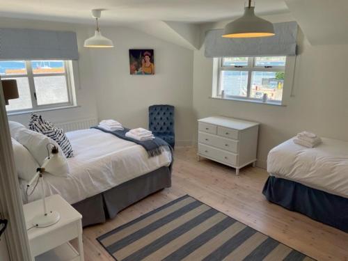 a bedroom with two beds and a dresser and a bed sidx sidx sidx sidx at The Cuan House in Strangford