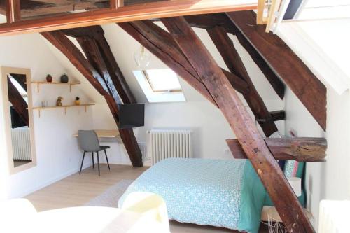 een slaapkamer met houten balken en een bed in een kamer bij Cocon plein centre ville - parking privé in Auxerre