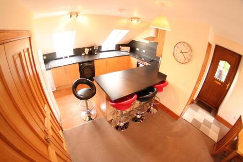 a kitchen with a table and some red chairs at Macallen in Nairn