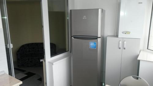 a stainless steel refrigerator in a room with a door at Ambiance Center in Bacău