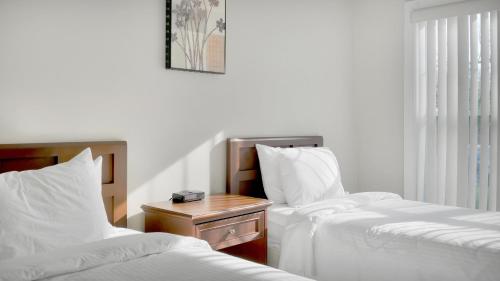 a hotel room with two beds and a night stand at The Cliffside Resort Condominiums in Greenport