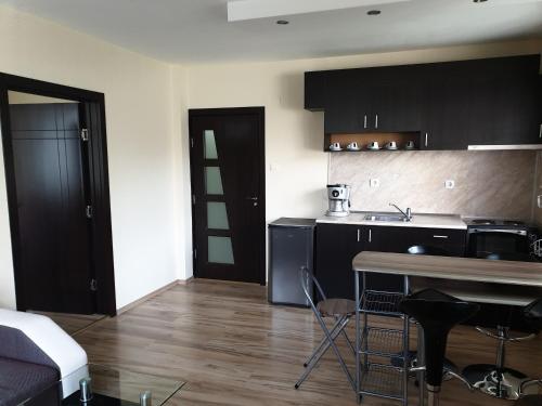 a kitchen with black cabinets and a table in a room at Apartment Tryavna in Tryavna