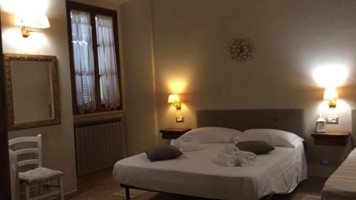 sypialnia z białym łóżkiem i ręcznikami w obiekcie Affittacamere Caliani w mieście Buonconvento