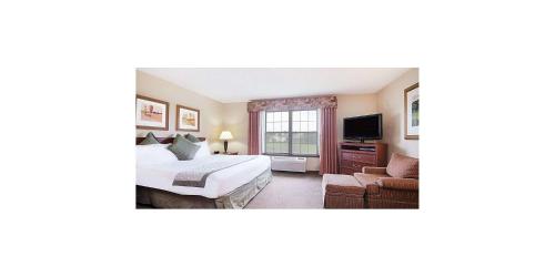 a hotel room with a bed and a tv at Wichita West Inn and Suites in Wichita