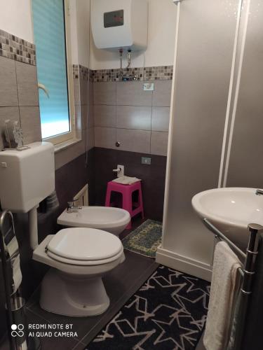 a bathroom with a white toilet and a sink at La Locandiera in Sersale