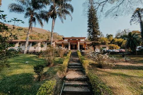a house with palm trees in front of a yard at Hotel Vila Bavária Petrópolis in Petrópolis