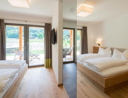 A bed or beds in a room at Das Leonhard - Naturparkhotel am Weissensee