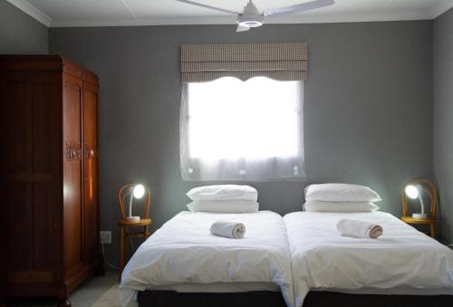 two twin beds in a bedroom with a window at Gasteria Grange in Calitzdorp