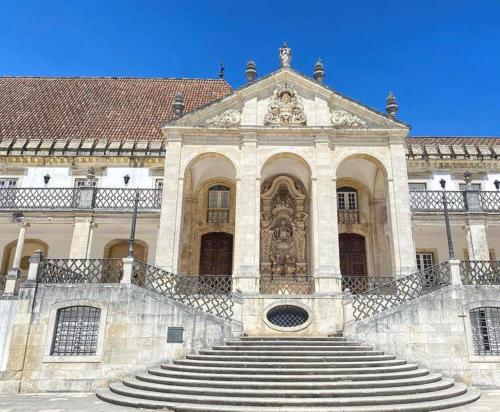 a large building with stairs in front of it at Gouveia Residence in Coimbra
