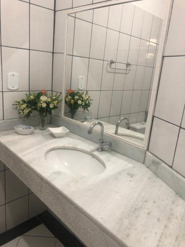 a bathroom with a sink and a mirror at Casa da Maisa in Porto Seguro