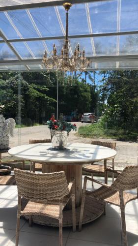 una mesa y sillas con un jarrón. en Casa da Maisa, en Porto Seguro