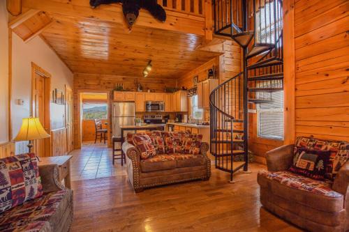 a living room with couches and a staircase in a cabin at Steps from Pkwy! Hot Tub~Pool Access~Fast WiFi in Pigeon Forge