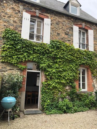 une maison en briques avec du lierre sur son côté dans l'établissement L'ANNEXE, à Saint-Quay-Portrieux