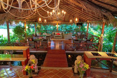 a patio area with tables, chairs, and umbrellas at Jardin del Eden Boutique Hotel in Tamarindo