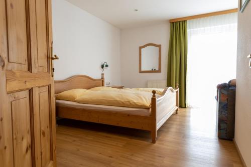 a bedroom with a bed with a wooden bed frame at Gasthof-Pension Riedl in Vöcklamarkt