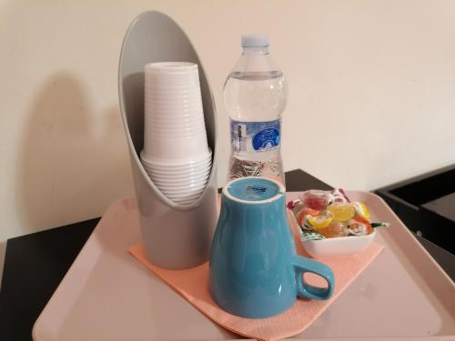 - un plateau avec une bouteille d'eau et une tasse dans l'établissement My sweet home, à Bari