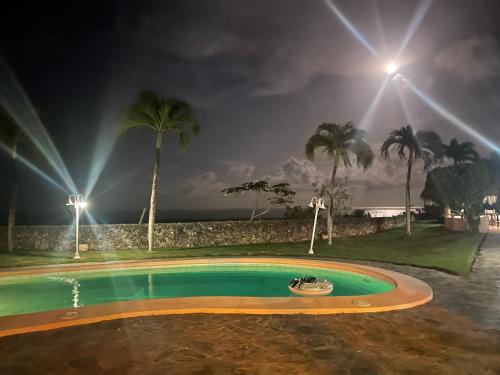 a swimming pool at night with palm trees and lights at Ocean Breeze Villa Carismar in Cabrera
