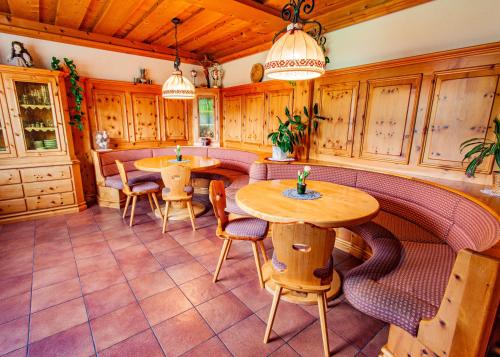 a kitchen with two tables and chairs and wooden cabinets at Gästehaus Hartweger in Haus im Ennstal
