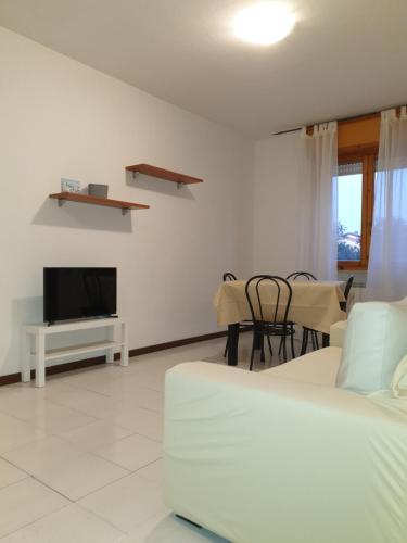 een woonkamer met een bed, een tv en een tafel bij Appartamento ALICE (CISANELLO-PISA) in Pisa