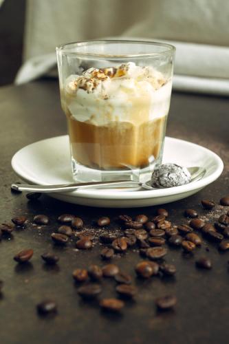 a cup of coffee on a plate with coffee beans at The 108 Hotel in Islamabad