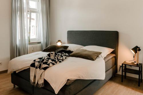 ein Schlafzimmer mit einem großen Bett mit weißer Bettwäsche und Kissen in der Unterkunft Little Loft Limburg in Limburg an der Lahn
