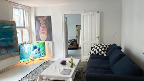 a living room with a blue couch and a table at Hygge Living - Heart of Copenhagen in Copenhagen