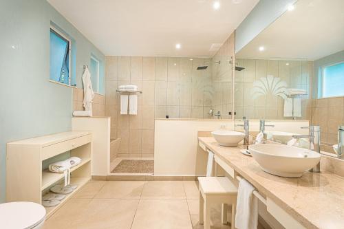 uma casa de banho com 2 lavatórios e um chuveiro em Jardin del Eden Boutique Hotel em Tamarindo