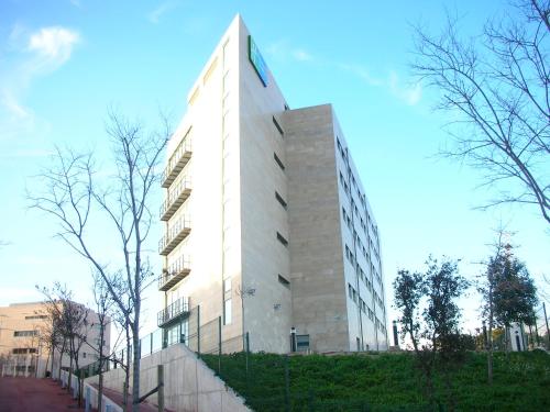 a white building with a clock on the side of it at Holiday Inn Express Sant Cugat by IHG in Sant Cugat del Vallès