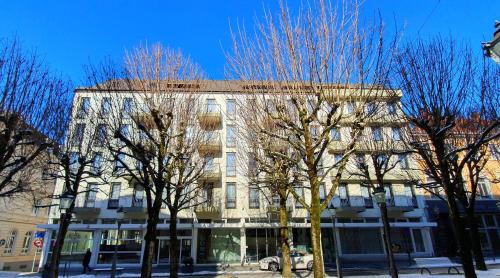 ein hohes Gebäude mit Bäumen davor in der Unterkunft Hotel Quellenhof in Baden-Baden