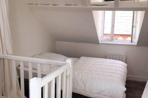 une petite chambre avec un lit et une fenêtre dans l'établissement Charmante Maison de Pêcheur au coeur de Trouville, à Trouville-sur-Mer