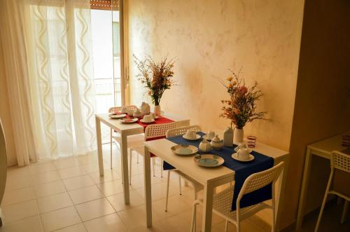 uma sala de jantar com duas mesas e cadeiras e uma janela em Apta Mihi B&B em Vico Equense