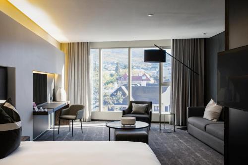 a hotel room with a bed and a large window at The Capital 15 on Orange Hotel & Spa in Cape Town