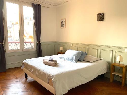 une chambre avec un lit avec des serviettes dessus dans l'établissement Marvellous Sunbathed 3BR at the heart of Paris, à Paris