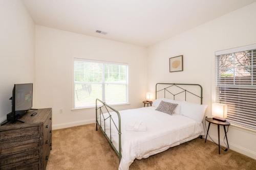 a bedroom with a bed and a flat screen tv at Open and Brilliant 2BR with Balcony and Gym in Charlotte