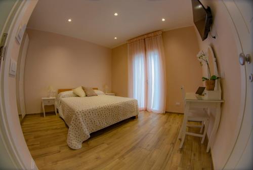 a bedroom with a bed and a table and a window at Il Granello in Fiumicino