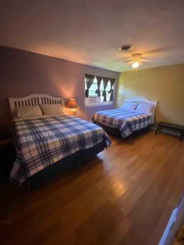 a bedroom with two beds and a wooden floor at Va Beach Town Center Privita Room in Virginia Beach
