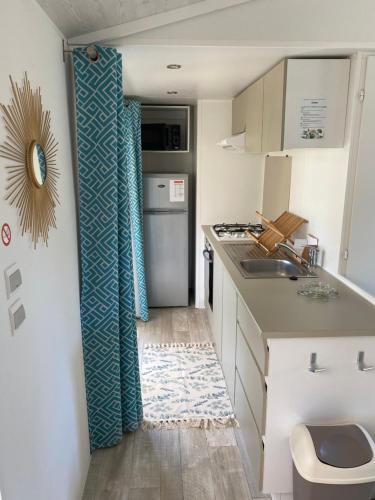 une petite cuisine avec un évier et un réfrigérateur dans l'établissement Mobil-Home Camping Club 5* Montalivet, à Vendays-Montalivet