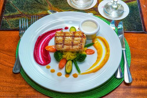 a plate of food with meat and vegetables on a table at Jardin del Eden Boutique Hotel in Tamarindo