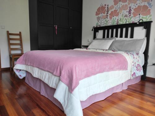a bedroom with a large bed with a pink and white bedspread at APARTAMENTO VALMAYOR in Potes